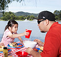 Father and daughter (6-7) having barbecue in park, San Rafael, California, USA